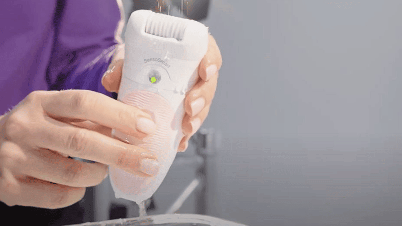 Épilateur électrique Braun Silk Epil 5 avec son bouton allumé, fonctionnel même après avoir été plongé dans l'eau